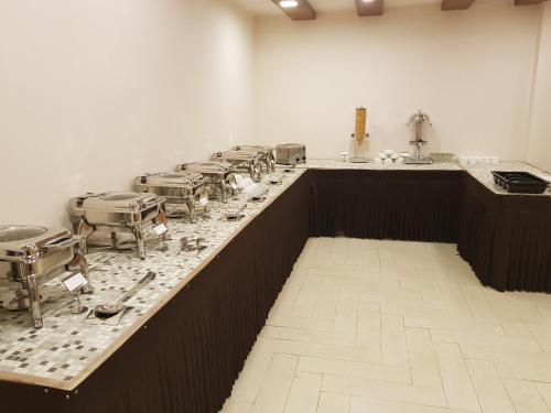 una cucina con un lungo bancone con una fila di sedie di Hotel Devlok Primal a Mussoorie