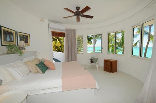 um quarto com uma cama e uma ventoinha de tecto em Villa Eva em Belle Mare