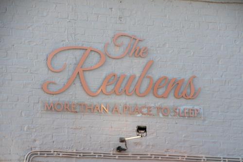 a sign on the side of a white brick wall at The Reubens in Bedale