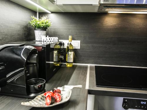 a kitchen with a toaster and some bottles of wine at Downtown Dream Apartmans in Szeged
