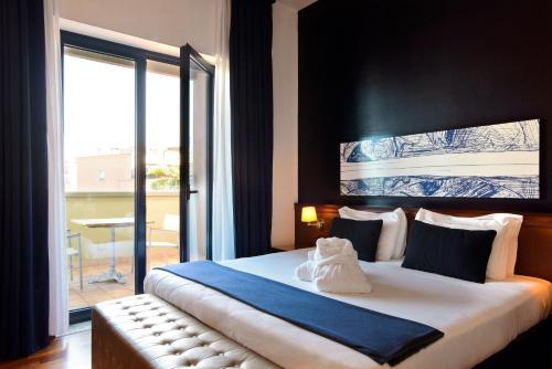 una camera da letto con un grande letto con una grande finestra di Grand Hotel Tiberio a Roma