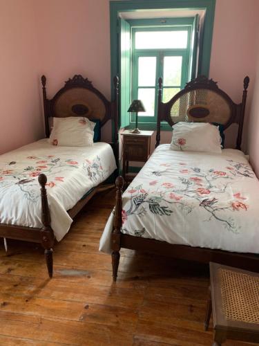 two twin beds in a room with a window at São Miguel House , Casa do Carvalhal in Santarém