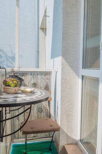 a table with a bowl of flowers on a balcony at Old Town Vintage Apartment Sturova in Košice