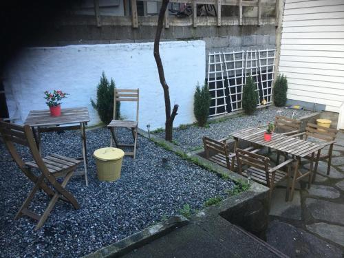 a patio with a table and benches and a tree at Bergen City Apartment Nygårdsgaten in Bergen