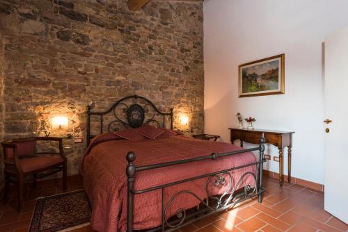 a bedroom with a bed and a brick wall at Il Chiostro Appartamenti & Suites in Suvereto