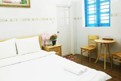 a bedroom with a bed and a table and chairs at Saigon City Center Hostel in Ho Chi Minh City