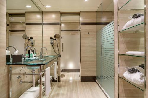 bagno con doccia in vetro e lavandino di Hotel Maydrit Airport a Madrid