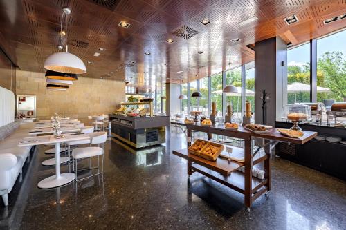a restaurant with a counter with food on it at Hotel Maydrit Airport in Madrid