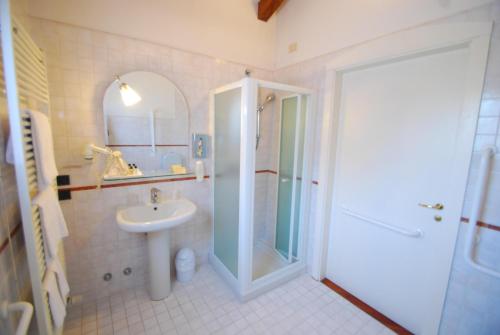 a bathroom with a shower and a sink and a shower backdoor at Alla Rocca Hotel Conference & Restaurant in Bazzano