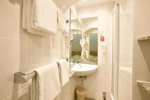 a white bathroom with a sink and a mirror at Römerhof in Stuttgart