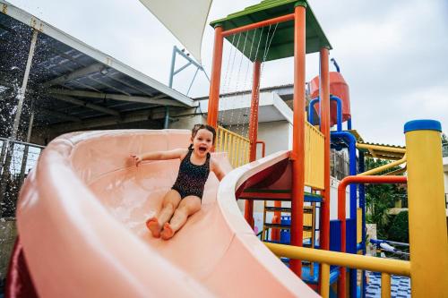 a young girl on a slide at a playground at FuramaXclusive Ocean Beach Seminyak Bali in Legian
