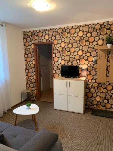 a living room with a wall covered in logs at Dorottya Vendégház in Miskolctapolca