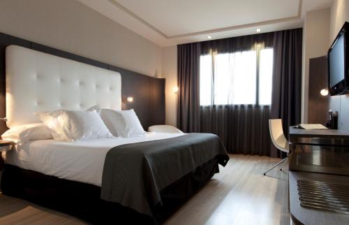 a hotel room with a large bed and a television at Hotel Maydrit Airport in Madrid