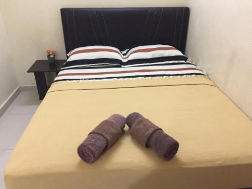 カンポン・ケママンにあるIlhamku Innの紫の靴下が置かれたベッド