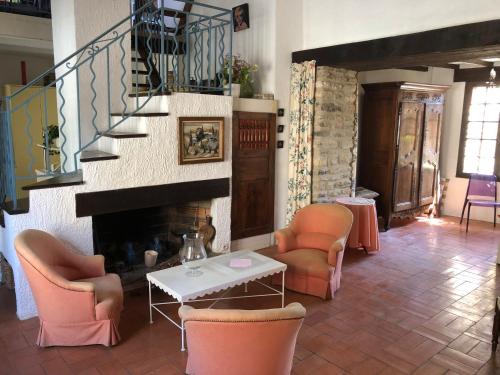 sala de estar con sillas y chimenea en MAISON PIERRE 128M JARDIN TERRASSE 5 MM SOMMIERES, en Aspères