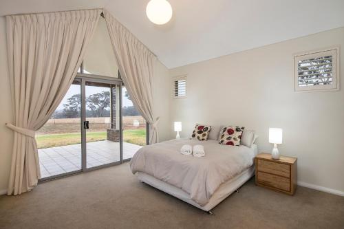 een slaapkamer met een bed en een glazen schuifdeur bij Metricup House - elegant country retreat in Wilyabrup