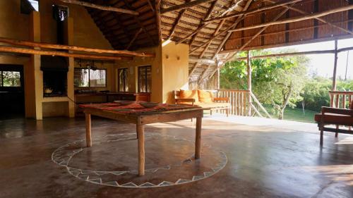 una sala de estar con una mesa en el centro de una habitación en Anastasea, Palm Tree Garden Lodging, en Praia do Tofo
