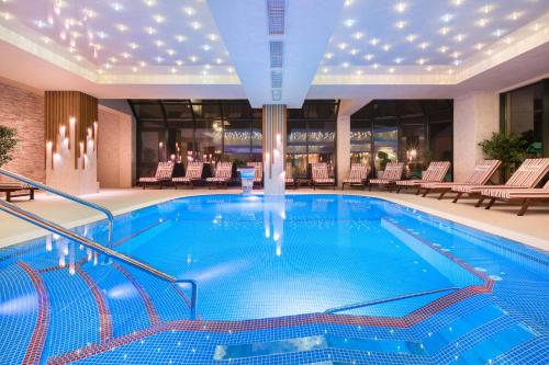 a large swimming pool in a hotel with chairs at Park & Spa Hotel Markovo in Plovdiv
