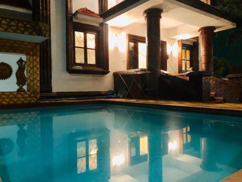 uma grande piscina numa casa com uma casa em West Valley Villa ,North Goa em Old Goa