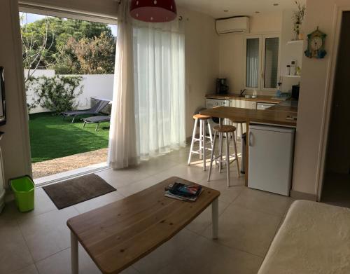 een woonkamer met een tafel en een keuken bij Les Jasmins in Sainte-Maxime