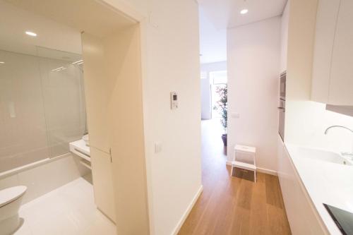 La salle de bains blanche est pourvue de toilettes et d'un lavabo. dans l'établissement FLH Restauradores Modern Studios, à Lisbonne