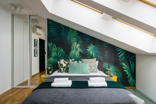 - une chambre avec un grand lit et du papier peint tropical dans l'établissement Urban Loft by LoftAffair, à Cracovie