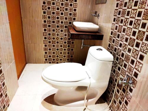 a bathroom with a toilet and a sink at City Hotel in Allahābād