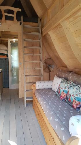 a log cabin with a bed in a room at Les CASAS La Champrenière in Le Boupère