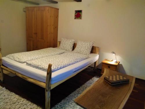 um quarto com uma cama e um armário de madeira em Kerti lak em Mór