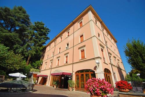 a large building with flowers in front of it at Alla Rocca Hotel Conference & Restaurant in Bazzano