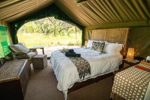 ein Schlafzimmer mit einem Bett in einem Zelt in der Unterkunft Tembe Elephant Park Lodge in Sihangwane