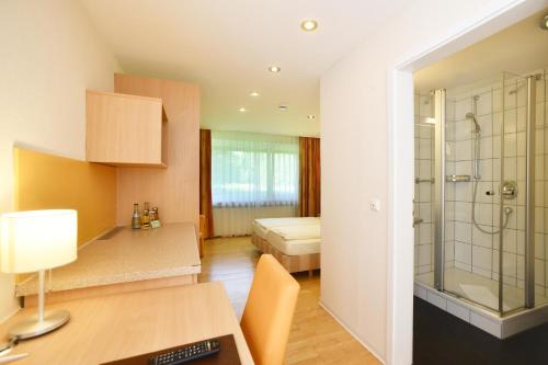 a bathroom with a shower and a bedroom at Kulinarium an der Glems in Stuttgart