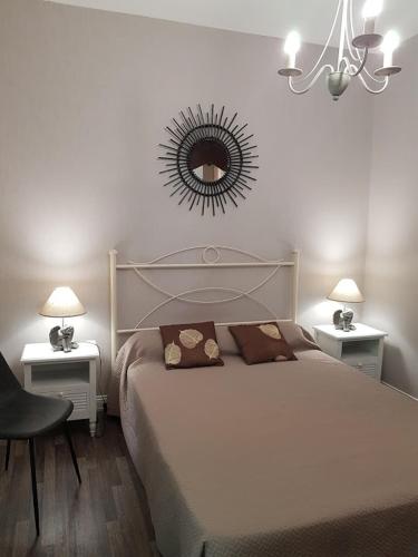 une chambre avec un lit et un miroir au mur dans l'établissement Studio Domaine des Oliviers, à Sarlat-la-Canéda