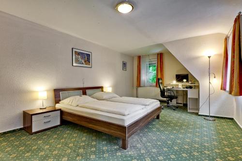 a bedroom with a bed and a desk and a chair at Kulinarium an der Glems in Stuttgart
