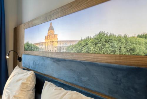 a large picture of a building on the wall of a bedroom at Smart Stay Hotel Station in Munich