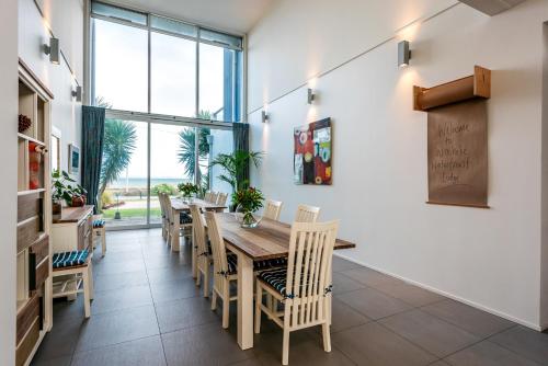 OneroaにあるWaiheke Waterfront Lodgeの木製のテーブルと椅子のあるダイニングルーム