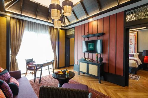 a living room with a couch and a television at Chala Number6 in Chiang Mai