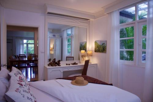 Coombs Cottage, Khaoyai, Mu Si في Ban Rai Khlong Sai: غرفة نوم مع سرير مع قبعة عليه