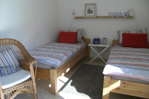 - une chambre avec deux chaises en osier et un lit dans l'établissement Ferienwohnung Schwanbergblick, à Mainbernheim