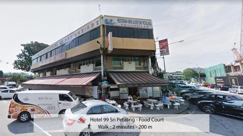a building with cars parked in a parking lot at Hotel 99 Sri Petaling (Bukit Jalil) in Kuala Lumpur