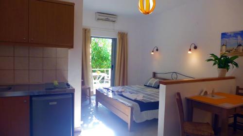 a bedroom with a bed and a kitchen with a table at Lion-Suites in Kalyves
