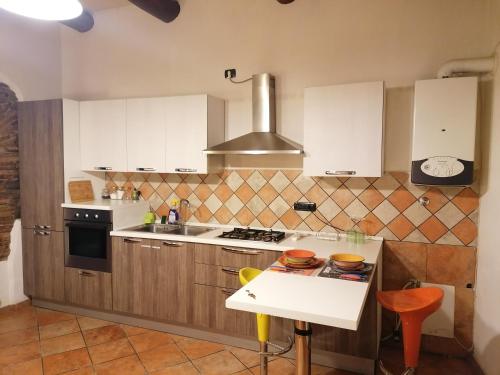 a kitchen with white cabinets and a stove top oven at Casa Traiano in Benevento