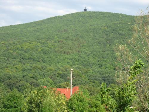 a hill with a house on top of it at Hegyi Panzió in Szilvásvárad