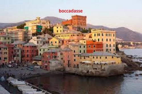 a group of buildings on a hill next to the water at memeapartments in Genova
