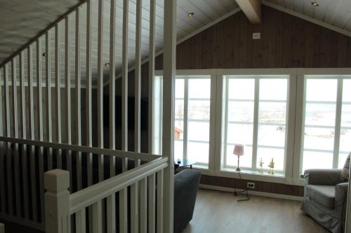 a living room with a staircase and windows at Torshaug 4 bedroom cabin in Gol