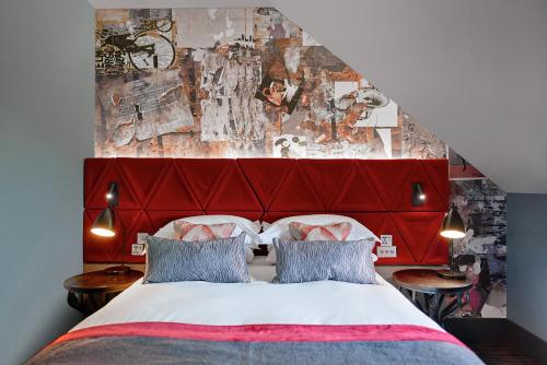 a bedroom with a large bed with a red headboard at Malmaison Edinburgh City in Edinburgh