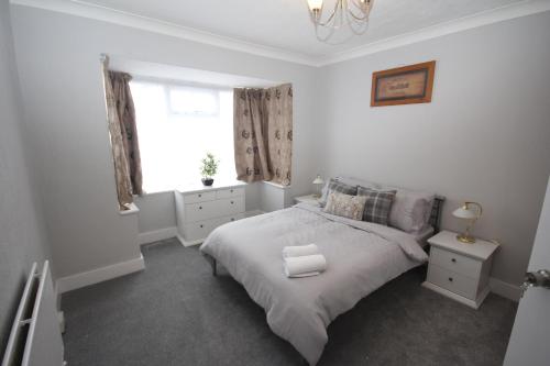 a white bedroom with a bed and a window at The Uxbridge House in Uxbridge