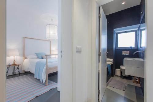ein Schlafzimmer mit einem Bett und ein Badezimmer mit einem Waschbecken in der Unterkunft Renovated Apart with Private Courtyard, By TimeCooler in Lissabon