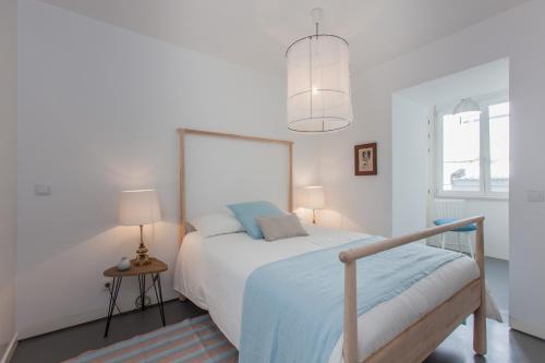ein weißes Schlafzimmer mit einem Bett und einer Lampe in der Unterkunft Renovated Apart with Private Courtyard, By TimeCooler in Lissabon