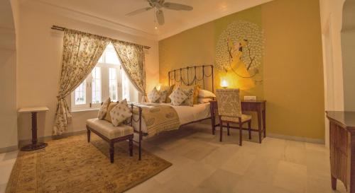 1 dormitorio con cama, escritorio y ventana en The Rohet House en Jodhpur